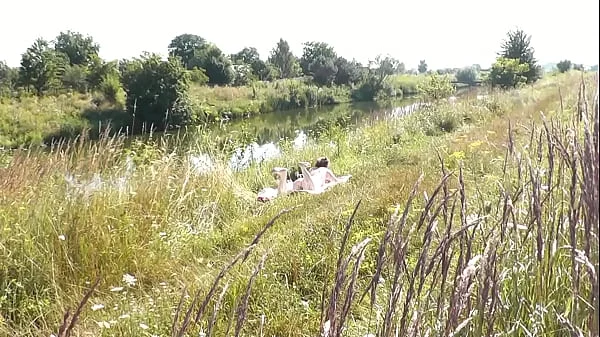 A casual passerby young guy saw a naked Milf sunbathing on river bank. Peeping. Spy camera. Naked in public. Nude beach. Wild beach