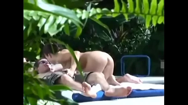Big tit girlfriend giving a handjob outside by the pool