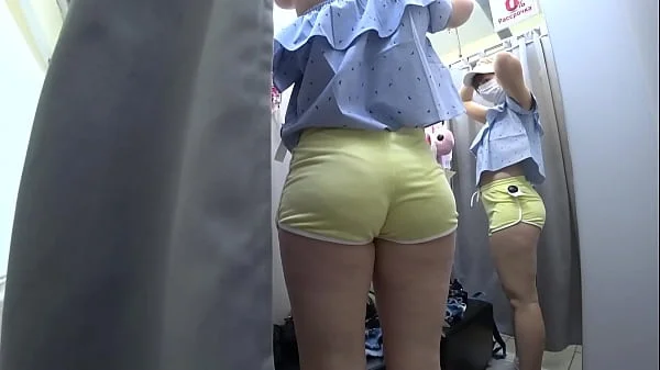 Voyeur in a public shopping center peeps into the changing room for a girl with a beautiful ass. Fetish.