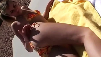 Hot blonde model shows off her body in a bikini in public