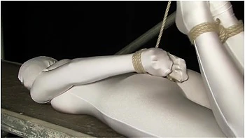 Babe Wrapped In White Zentai Suit Enjoys To Be Bondaged To A Metal Pole