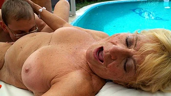 A mature woman with big tits has sex right in the pool